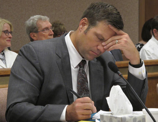 Kansas Secretary of State Kris Kobach listens and takes note as a judge declares in Shawnee County District Court that the state must count potentially thousands of votes from people who registered without providing documentation of their U.S. citizenship, Friday, July 29, 2016, in Topeka, Kan. Kobach had directed local election officials to count only their votes in federal races, not state and local ones. (AP Photo/John Hanna)