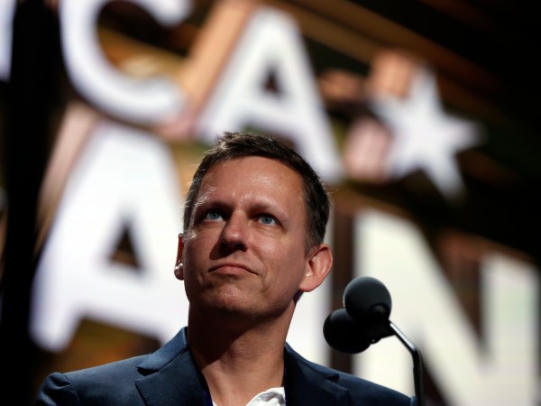 Billionaire tech investor Peter Thiel look overr the podium before the start of the second day session of the Republican National Convention in Cleveland, Tuesday, July 19, 2016. (AP Photo/Carolyn Kaster)