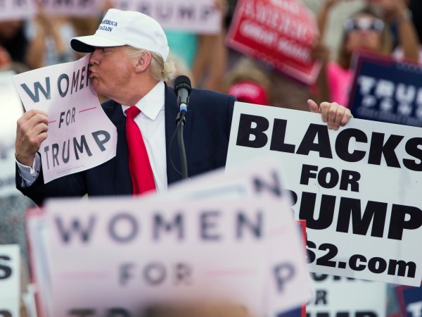 Republican presidential candidate Donald Trump kisses a "Women for Trump" sign during a campaign rally, Wednesday, Oct. 12, 2016, in Lakeland, Fla. (AP Photo/ Evan Vucci)