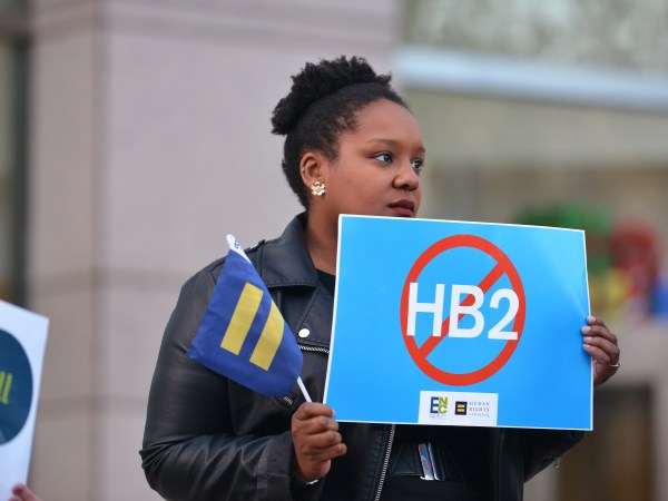 Cassandra Thomas of Human Rights Campaign holds a sign advocating the repeal of HB2 as Executive Director Chad Griffin, President of Human Rights Campaign and Executive Director of Equality NC, Chris Sgro, discuss the North Carolina election results at the Government Center on Wednesday, Dec. 7, 2016, in Charlotte. (Brian Gomsak/AP Images for Human Rights Campaign)