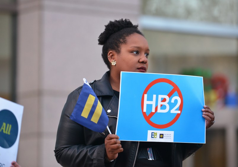 Cassandra Thomas of Human Rights Campaign holds a sign advocating the repeal of HB2 as Executive Director Chad Griffin, President of Human Rights Campaign and Executive Director of Equality NC, Chris Sgro, discuss the North Carolina election results at the Government Center on Wednesday, Dec. 7, 2016, in Charlotte. (Brian Gomsak/AP Images for Human Rights Campaign)
