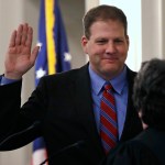 N.H. Gov. Chris Sununu raises his hand as he is sworn in at the State House in Concord, N.H., Thursday, Jan. 5, 2017. Sununu, the first Republican to hold the corner office in a dozen years, follows in the footsteps of his father, former N.H. Governor John H. Sununu. (AP Photo/Charles Krupa)