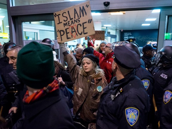 Protesters are surrounded by police officers and travelers as they pass through an exit of Terminal 4 at John F. Kennedy International Airport in New York, Saturday, Jan. 28, 2017 after earlier in the day two Iraqi refugees were detained while trying to enter the country. On Friday, Jan. 27, President Donald Trump signed an executive order suspending all immigration from countries with terrorism concerns for 90 days. Countries included in the ban are Iraq, Syria, Iran, Sudan, Libya, Somalia and Yemen, which are all Muslim-majority nations. (AP Photo/Craig Ruttle)