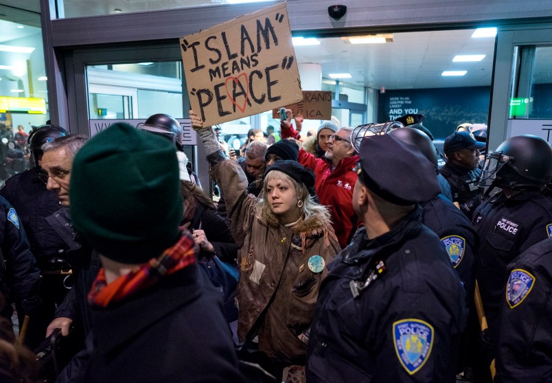 Protesters are surrounded by police officers and travelers as they pass through an exit of Terminal 4 at John F. Kennedy International Airport in New York, Saturday, Jan. 28, 2017 after earlier in the day two Iraqi refugees were detained while trying to enter the country. On Friday, Jan. 27, President Donald Trump signed an executive order suspending all immigration from countries with terrorism concerns for 90 days. Countries included in the ban are Iraq, Syria, Iran, Sudan, Libya, Somalia and Yemen, which are all Muslim-majority nations. (AP Photo/Craig Ruttle)