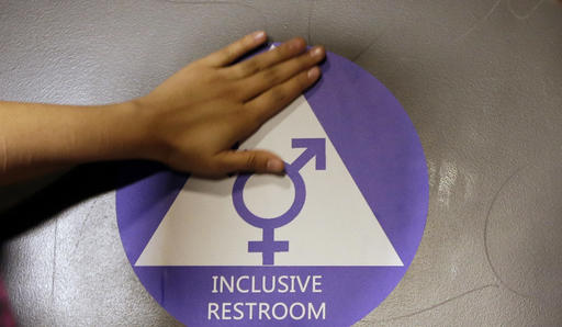 HOLD FOR STORY FILE - In this May 17, 2016 file photo, a new sticker is placed on the door at the ceremonial opening of a gender neutral bathroom at Nathan Hale High School in Seattle. Hundreds of parents across the country have called on President Donald Trump to embrace Obama-era protections for transgender students that call for letting them use school bathrooms in accordance with their gender identity. In a letter, sent to the president by the Human Rights Campaign late Tuesday, Feb. 14, 2017, more than 780 parents stressed that “all students deserve equal access to a safe, welcoming school and a high quality education no matter who they are.”  (AP Photo/Elaine Thompson, File)