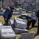 Northeast Philadelphia Police Dective Timothy McIntyre, center, dusts one of the many headstones that were knocked down, for fingerprints as Dectective Nick McReynolds, left, looks on on Sunday afternoon. Vandals strike the Jewish Mount Carmel Cemetery at Frankford and Cheltenham Avenues. Awaiting police details. 02/26/2017  MICHAEL BRYANT / Staff Photographer