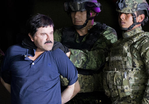 FILE - In this Jan. 8, 2016 file photo, a handcuffed Joaquin "El Chapo" Guzman is made to face the press as he is escorted to a helicopter by Mexican soldiers and marines at a federal hangar in Mexico City. Mexican President Enrique Pena Nieto announced Guzman was recaptured six months after escaping from a maximum security prison. (AP Photo/Eduardo Verdugo, File)