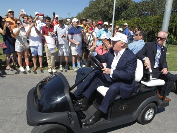Republican presidential candidate Donald Trump drives himself around the golf course to watch the final round of the Cadillac Championship golf tournament, Sunday, March 6, 2016, in Doral, Fla. (AP Photo/Luis Alvarez)