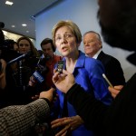 U.S. Sen. Elizabeth Warren, D-Mass., center, takes question from members of the media after addressing business leaders during a New England Council luncheon at a hotel, Monday, March 27, 2017, in Boston. (AP Photo/Steven Senne)