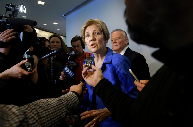 U.S. Sen. Elizabeth Warren, D-Mass., center, takes question from members of the media after addressing business leaders during a New England Council luncheon at a hotel, Monday, March 27, 2017, in Boston. (AP Photo/Steven Senne)