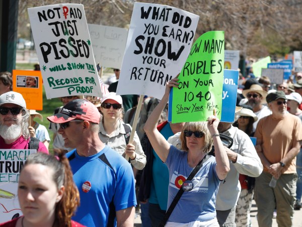 Protesters carry placards during a rally and march in downtown Denver Saturday, April 15, 2017. The rally in Denver was one of dozens in cities nationwide to call on President Donald Trump to release his tax returns, saying Americans deserve to know about his business ties and potential conflicts of interest. (AP Photo/David Zalubowski)