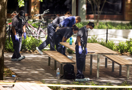 Officials search the scene of a homicide on the University of Texas at Austin campus on Monday May 1, 2017.  (AP Photo/Austin American-Statesman, Jay Janner)