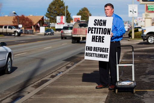 FILE--In this Dec. 8, 2015, file photo, Rick Martin, the head of the Committee to End the Colle of Southern Idaho’s Refugee Center, works to gather petition signatures in Twin Falls, Idaho.  . Twin Falls City Council members on Monday approved the “neighborly community” resolution affirming its role as a welcoming city rather than adopt policies defying U.S. immigration officials. (AP Photo/Otto Kitsinger, file)
