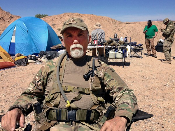 FILE - In this April 16, 2014 file photo, Jerry DeLemus, of Rochester, N.H., sits with a group of self-described militia members camping on rancher Cliven Bundy’s ranch near Bunkerville, Nev. Delemus one of two defendants are set to become the first to plead guilty in Nevada to federal charges stemming from an armed confrontation with U.S. land management agents near Nevada rancher Cliven Bundy’s ranch in 2014.DeLemus of New Hampshire is expected to enter his plea Tuesday, Aug. 23. (AP Photo/Ken Ritter, File)
