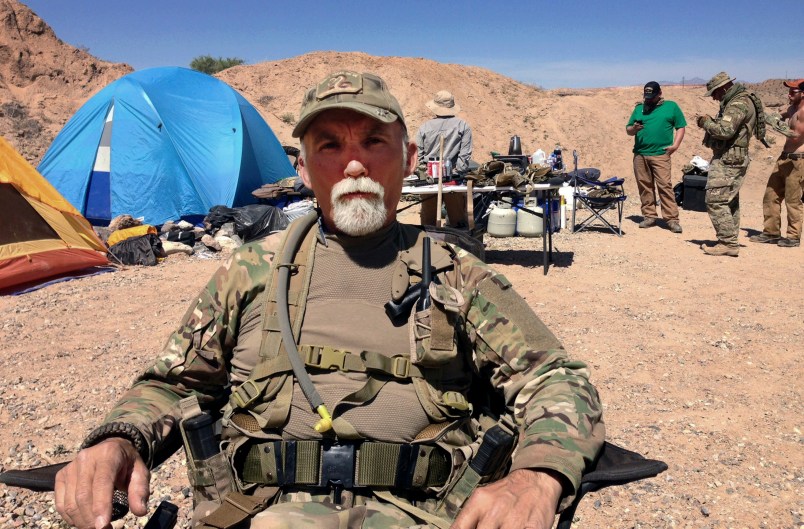 FILE - In this April 16, 2014 file photo, Jerry DeLemus, of Rochester, N.H., sits with a group of self-described militia members camping on rancher Cliven Bundy’s ranch near Bunkerville, Nev. Delemus one of two defendants are set to become the first to plead guilty in Nevada to federal charges stemming from an armed confrontation with U.S. land management agents near Nevada rancher Cliven Bundy’s ranch in 2014.DeLemus of New Hampshire is expected to enter his plea Tuesday, Aug. 23. (AP Photo/Ken Ritter, File)