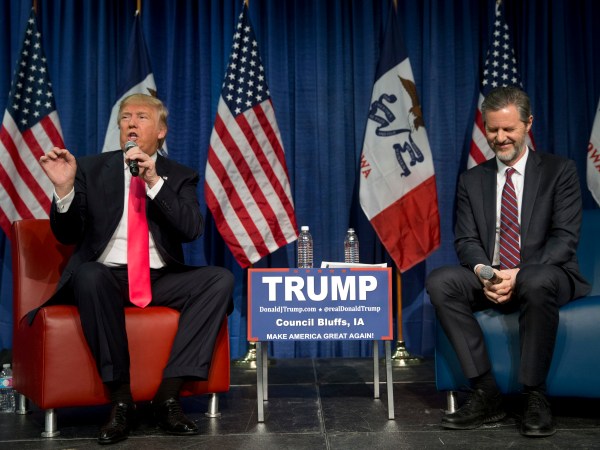 Jerry Falwell Jr., president of Liberty University, smiles as he listens to Republican presidential candidate Donald Trump, left, at a rally Sunday, Jan. 31, 2016, in Council Bluffs, Iowa. (AP Photo/Jae C. Hong)