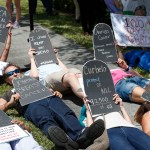 Demonstrators lie down during a health care protest outside U.S. Rep. Carlos Curbelo's offices, Thursday, May 4, 2017, in Miami. (AP Photo/Wilfredo Lee)