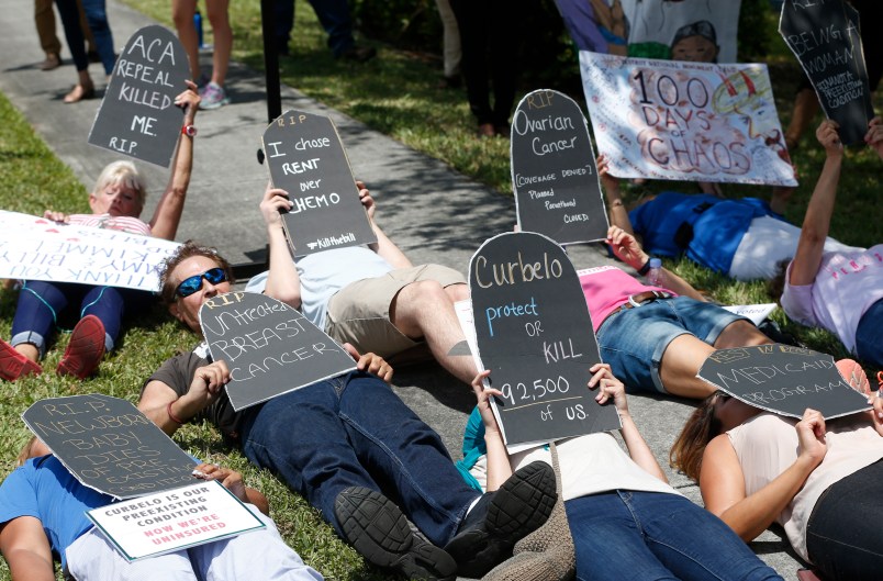 Demonstrators lie down during a health care protest outside U.S. Rep. Carlos Curbelo's offices, Thursday, May 4, 2017, in Miami. (AP Photo/Wilfredo Lee)