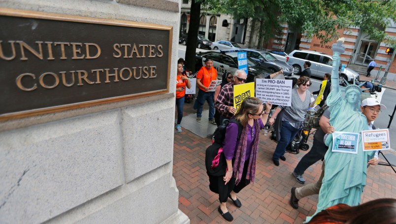 Protesters hold signs and march outside the US  4th Circuit Court of Appeals in Richmond, Va., Monday, May 8, 2017.  The court will examine a ruling that blocks the administration from temporarily barring new visas for citizens of Iran, Libya, Somalia, Sudan, Syria and Yemen. It's the first time an appeals court will hear arguments on the revised travel ban, which is likely destined for the U.S. Supreme Court.(AP Photo/Steve Helber)