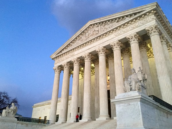 People stand on the steps of the Supreme Court at sunset on Saturday, Feb. 13, 2016, in Washington. On Saturday, Feb. 13, 2016, the U.S. Marshals Service confirmed that Scalia has died at the age of 79. (AP Photo/Jon Elswick)