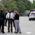 Authorities confer, Monday, June 5, 2017, near Orlando, Fla. Law enforcement authorities said there were "multiple fatalities" following a Monday morning shooting in an industrial area near Orlando. On its officials Twitter account Monday morning, the Orange County Sheriff's Office said the "situation" has been contained. They said Orange County Sheriff Jerry Demmings will make a statement "as soon as info is accurate." (AP Photo/John Raoux)