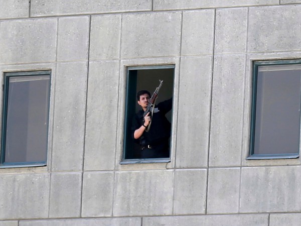 An armed man stands in a window of the parliament building in Tehran, Iran, Wednesday, June 7, 2017. Several attackers stormed into Iran's parliament and a suicide bomber targeted the shrine of Ayatollah Ruhollah Khomeini on Wednesday, killing a security guard and wounding several other people in rare twin attacks, with the shooting at the legislature still underway. (Fars News Agency, Omid Vahabzadeh via AP)