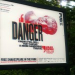 In this June 7, 2017 photo, "Danger knows full well that Caesar is more dangerous than he," reads a sign promoting The Public Theater's production of Julius Caesar in New York's Central Park. Gregg Henry, the actor who starred in Shakespeare's "Julius Caesar" on a New York stage wears a Donald Trump-like costume to play the powerful Roman politician betrayed by his top aide and knifed to death. (AP Photo/Verena Dobnik)
