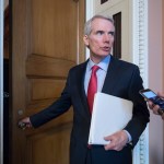 FILE - In this Tuesday, June 20, 2017 file photo, Sen. Rob Portman, R-Ohio, pauses for a reporter's question as he arrives at a closed-door GOP strategy session on the Republican health care overhaul with Vice President Mike Pence, Senate Majority Leader Mitch McConnell, R-Ky., and others, at the Capitol in Washington. Days after it's release, Portman faces intense pressure back home to oppose the Senate’s GOP health care bill. (AP Photo/J. Scott Applewhite)