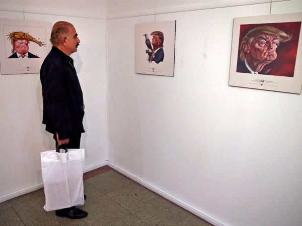 A visitor looks at a cartoon mocking the U.S. President Donald Trump in an exhibition in Tehran, Iran, Monday, July 3, 2017. Iranians have organized a "Trumpism" cartoon contest in which hundreds of participants have been invited to submit artwork mocking the U.S. leader. (AP Photo/Vahid Salemi)