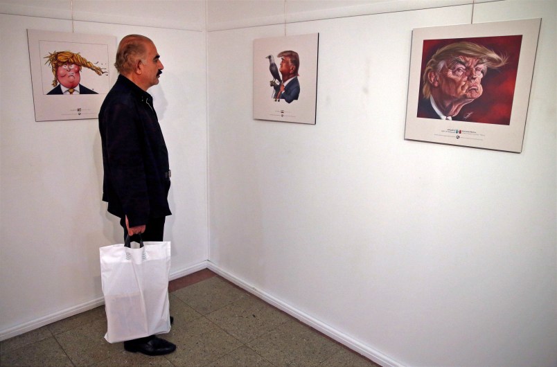 A visitor looks at a cartoon mocking the U.S. President Donald Trump in an exhibition in Tehran, Iran, Monday, July 3, 2017. Iranians have organized a "Trumpism" cartoon contest in which hundreds of participants have been invited to submit artwork mocking the U.S. leader. (AP Photo/Vahid Salemi)
