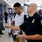 U.S. Customs and Border Protection officer Sanan Jackson (right) helps a passenger (no ID) navigate the new face recognition kiosks at United Airlines gate E7 for a flight to Tokyo at Bush Intercontinental Airport in Houston, TX, June 29, 2017. (Michael Wyke / For the  Chronicle)