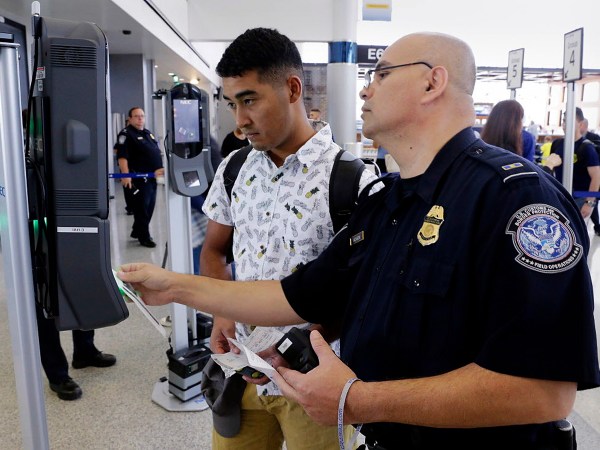 U.S. Customs and Border Protection officer Sanan Jackson (right) helps a passenger (no ID) navigate the new face recognition kiosks at United Airlines gate E7 for a flight to Tokyo at Bush Intercontinental Airport in Houston, TX, June 29, 2017. (Michael Wyke / For the  Chronicle)