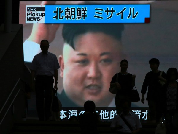 People walk past a TV news showing an image of North Korean leader Kim Jong Un while reporting North Korea's missile test which landed in the waters of Japan's economic zone (EEZ) in Tokyo Tuesday, July 4, 2017.  (AP Photo/Eugene Hoshiko)