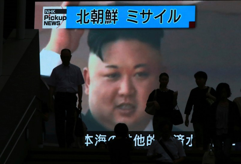 People walk past a TV news showing an image of North Korean leader Kim Jong Un while reporting North Korea's missile test which landed in the waters of Japan's economic zone (EEZ) in Tokyo Tuesday, July 4, 2017.  (AP Photo/Eugene Hoshiko)