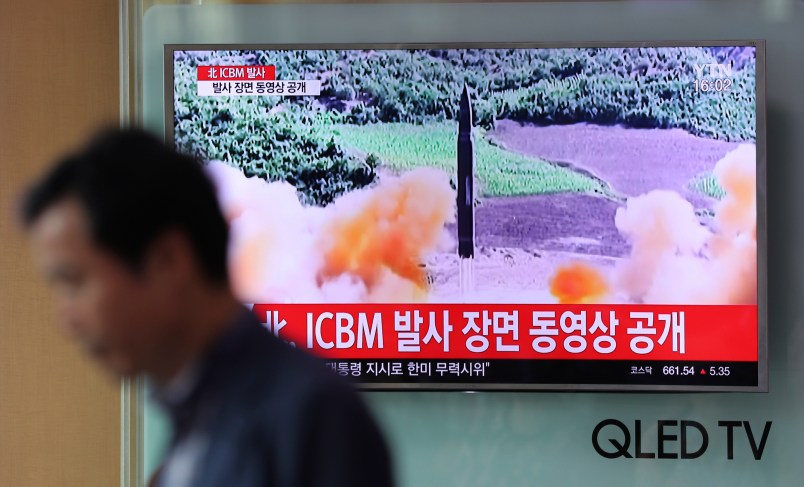A man walks by a TV screen showing a local news program reporting about North Korea's missile firing at Seoul Train Station in Seoul, South Korea, Wednesday, July 5, 2017. North Korea's leader Kim Jong Un vowed his nation would "demonstrate its mettle to the U.S." and never put its weapons programs up for negotiations a day after test-launching its first intercontinental ballistic missile. The hard line suggests more tests are being prepared as the country tries to perfect a nuclear missile capable of striking anywhere in the United States. The letters read "North Korea, release an ICBM launching video." (AP Photo/Lee Jin-man)