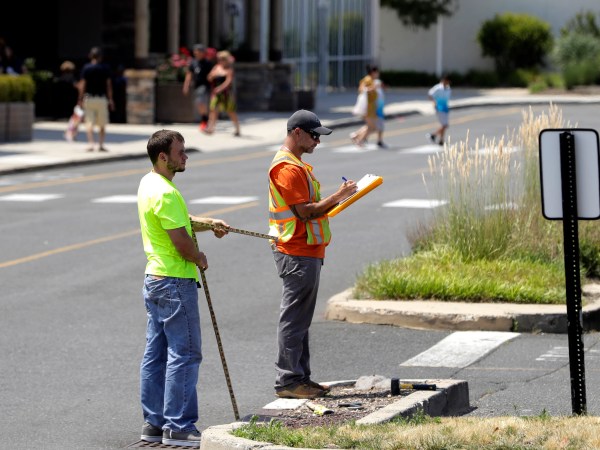 --PLEASE HOLD-- In a photo taken Wednesday, July 5, 2017, two men survey an area in the parking lot of Monmouth Mall in Eatontown, N.J. Four local women are the plaintiffs in a court case against Jared Kushner, who is trying to expand the mall and build an apartment complex. Residents are upset because the complex encroaches onto their backyards and it will bring unwanted traffic and noise to the town. The plaintiffs claim Kushner is getting special treatment as the project has sped through the process in a rare manner. (AP Photo/Julio Cortez)