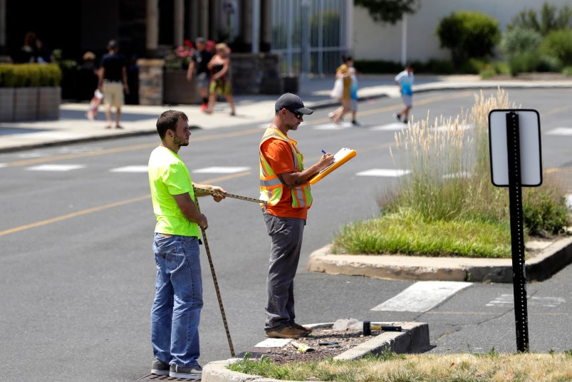 --PLEASE HOLD-- In a photo taken Wednesday, July 5, 2017, two men survey an area in the parking lot of Monmouth Mall in Eatontown, N.J. Four local women are the plaintiffs in a court case against Jared Kushner, who is trying to expand the mall and build an apartment complex. Residents are upset because the complex encroaches onto their backyards and it will bring unwanted traffic and noise to the town. The plaintiffs claim Kushner is getting special treatment as the project has sped through the process in a rare manner. (AP Photo/Julio Cortez)