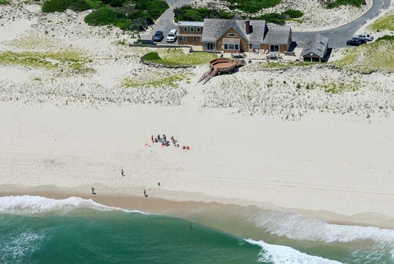In this Sunday, July 2, 2017, photo, New Jersey Gov. Chris Christie uses the beach with his family and friends at the governor's summer house at Island Beach State Park in New Jersey. Christie is defending his use of the beach, closed to the public during New Jersey's government shutdown, saying he had previously announced his vacation plans and the media had simply "caught a politician keeping his word." (Andrew Mills/NJ Advance Media via AP)