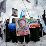 Demonstrators hold posters reading "There is no place for juvenile justice in Russia," "I want all children be happy" during a massive rally to back the ban on U.S. adoptions of Russian children in Moscow, Saturday, March 2, 2013. Russia voiced strong skepticism Saturday about the U.S. autopsy on Max Shatto, a 3-year-old adopted Russian boy in Texas and demanded further investigation as thousands rallied in Moscow to support the Kremlin ban on U.S. adoptions of Russian children. (AP Photo/Alexander Zemlianichenko)