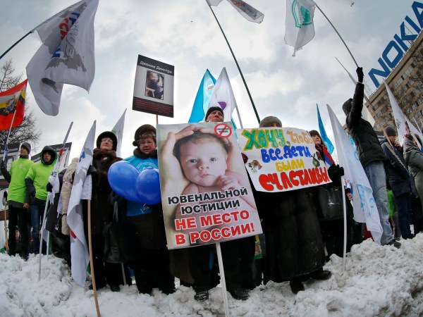 Demonstrators hold posters reading "There is no place for juvenile justice in Russia," "I want all children be happy" during a massive rally to back the ban on U.S. adoptions of Russian children in Moscow, Saturday, March 2, 2013. Russia voiced strong skepticism Saturday about the U.S. autopsy on Max Shatto, a 3-year-old adopted Russian boy in Texas and demanded further investigation as thousands rallied in Moscow to support the Kremlin ban on U.S. adoptions of Russian children. (AP Photo/Alexander Zemlianichenko)
