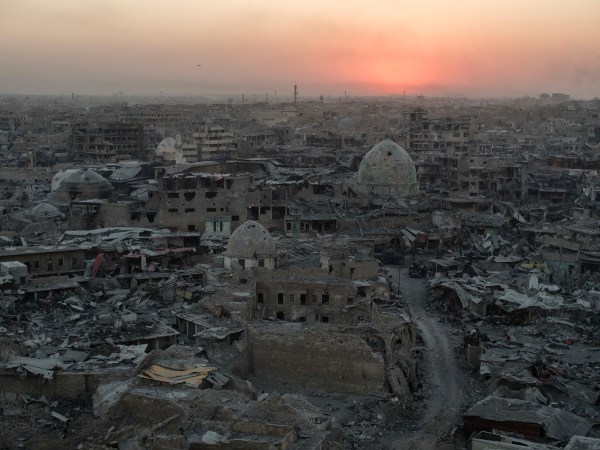 In this July 11, 2017 , the sun sets behind destroyed homes and buildings on the west side of Mosul, Iraq. (AP Photo/Felipe Dana)