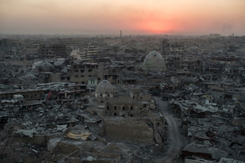 In this July 11, 2017 , the sun sets behind destroyed homes and buildings on the west side of Mosul, Iraq. (AP Photo/Felipe Dana)