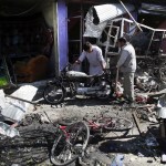 Men look at the remain of their properties at the site of a suicide attack in Kabul, Afghanistan, Monday, July 24, 2017. A suicide car bomb killed 12 people as well as the bomber and injured another 10 people early Monday morning in a western neighborhood of Afghanistan's capital where several prominent politicians reside, a government official said. (AP Photos/Massoud Hossaini)