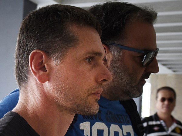 A Russian man is escorted by police officers as he  arrives at a courthouse at the northern Greek city of Thessaloniki, on Wednesday, July 26, 2017. Greek authorities say they have arrested a Russian man wanted in the United States on suspicion of masterminding a money laundering operation involving at least $4 billion through bitcoin transactions. (AP Photo/Giannis Papanikos)