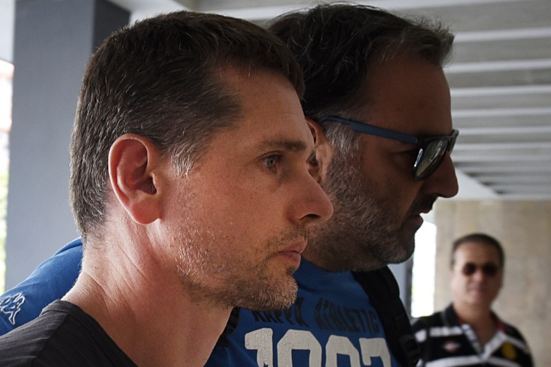 A Russian man is escorted by police officers as he  arrives at a courthouse at the northern Greek city of Thessaloniki, on Wednesday, July 26, 2017. Greek authorities say they have arrested a Russian man wanted in the United States on suspicion of masterminding a money laundering operation involving at least $4 billion through bitcoin transactions. (AP Photo/Giannis Papanikos)