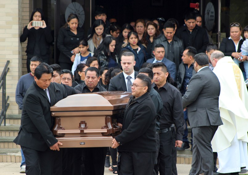 FILE - In this April 19, 2017 file photo, the casket of Justin Llivicura, 16, is carried from St. Joseph the Worker Church after Llivicura's funeral in East Patchogue, N.Y. Llivicura, 16, was one of four young men found slain in a suspected MS-13 gang killing in a park in Central Islip, N.Y., on April 12. An onslaught of gang killings on Long Island, much of it involving teenage victims, has caught the attention of President Donald Trump, who is set to visit one of the towns hit hardest by the violence.  (AP Photo/Frank Eltman, File)