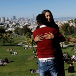 HOLD FOR STORY MOVING SUNDAY DAYSIDEIn this July 14, 2017 photo, Julie Rajagopal, facing, hugs her 16-year-old foster child from Eritrea after posing for photos at Dolores Park in San Francisco. Trump administration travel bans declared to block terrorists also are halting a small, three-decade-old program bringing orphan refugee children to waiting foster families in the United States. (AP Photo/Jeff Chiu)