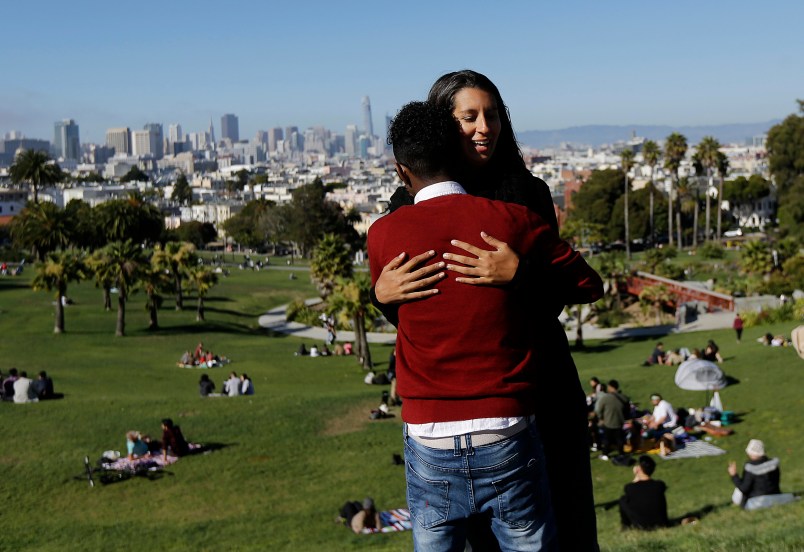 HOLD FOR STORY MOVING SUNDAY DAYSIDEIn this July 14, 2017 photo, Julie Rajagopal, facing, hugs her 16-year-old foster child from Eritrea after posing for photos at Dolores Park in San Francisco. Trump administration travel bans declared to block terrorists also are halting a small, three-decade-old program bringing orphan refugee children to waiting foster families in the United States. (AP Photo/Jeff Chiu)