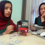 Teenage girl Sumaya Farooqi, 14, left, from Afghanistan Robotic House, a private training institute, practices with her colleagues at the Better Idea Organization center in Herat,  Afghanistan, Thursday, July 6, 2017. Six female students from Afghanistan who had hoped to participate in an international robotics competition in the U.S. this month will be forced to watch via video link from their hometown in Herat province after the U.S. denied them visas. (AP Photos/Ahmad Seir)