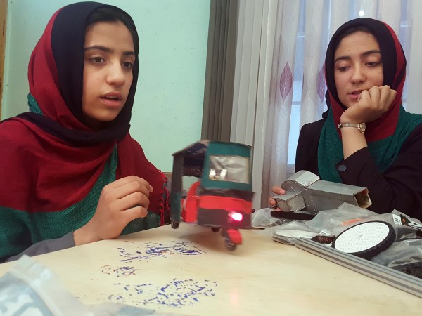 Teenage girl Sumaya Farooqi, 14, left, from Afghanistan Robotic House, a private training institute, practices with her colleagues at the Better Idea Organization center in Herat,  Afghanistan, Thursday, July 6, 2017. Six female students from Afghanistan who had hoped to participate in an international robotics competition in the U.S. this month will be forced to watch via video link from their hometown in Herat province after the U.S. denied them visas. (AP Photos/Ahmad Seir)